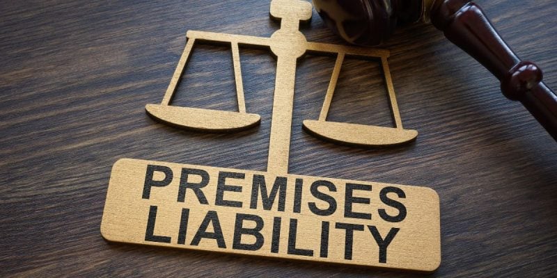 a golden scale symbol with premises liability written on it