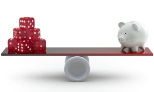a balance beam with dice on one end and a piggy bank on the other