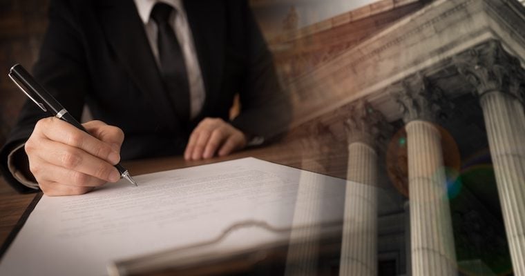 hand signing papers besides building columns