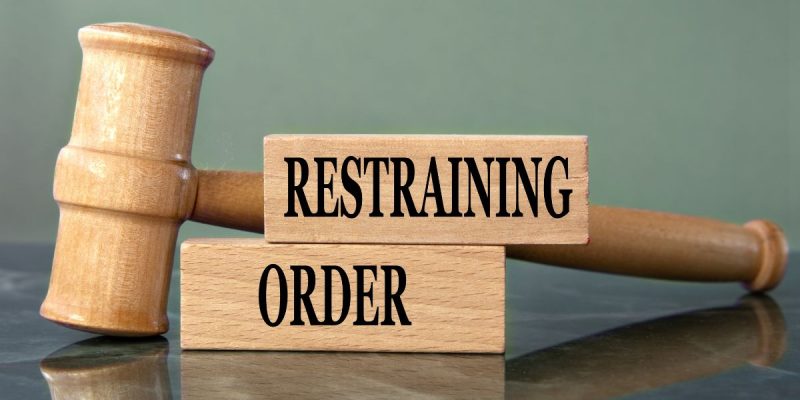 two blocking reading restraining order next to a gavel