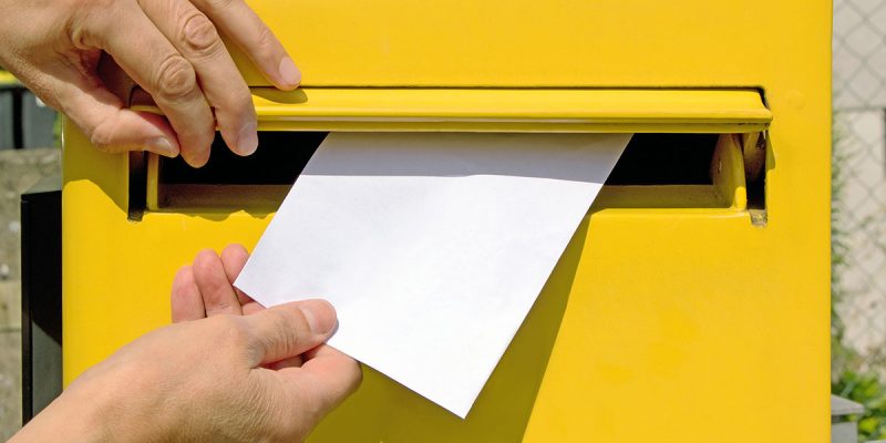 Postage person mailing letter yellow mailbox