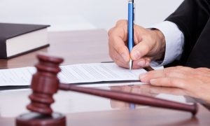 a contract being sign next to a gavel