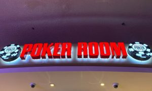 a world series of poke room sign hanging over the poker room in las vegas