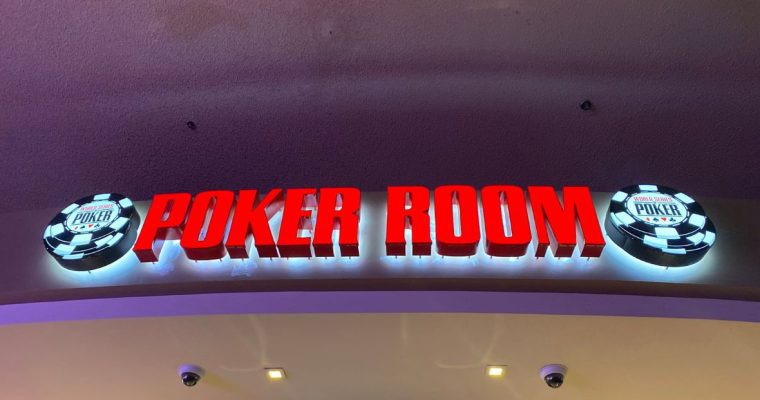 a world series of poke room sign hanging over the poker room in las vegas