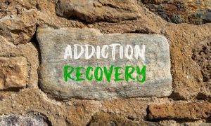 a stone in a wall that has addiction recovery written on it