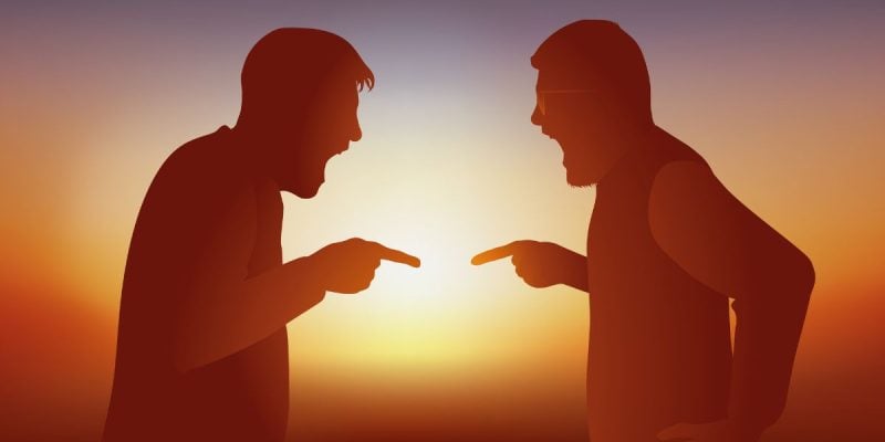 a pair of men arguing in the shadow of a backlight