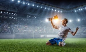 a soccer player celebrating with a trophy