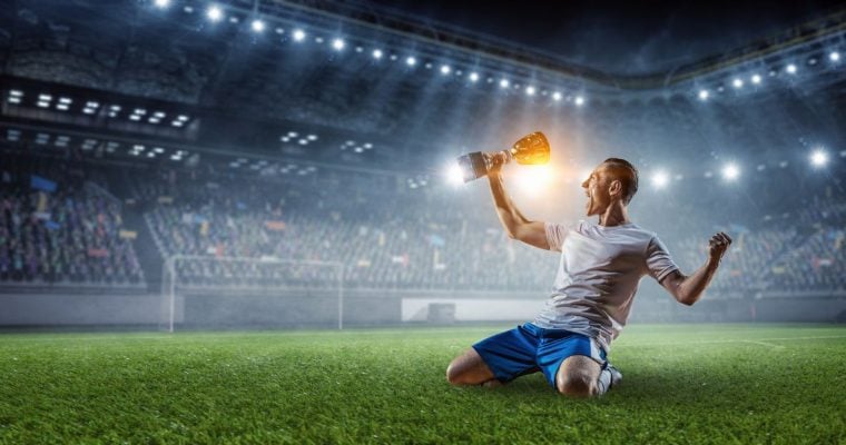 a soccer player celebrating with a trophy