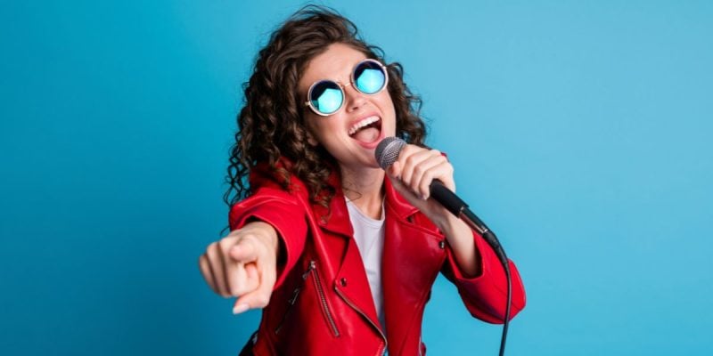a woman signing in front of a blue background