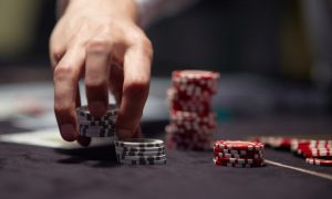 a dealers hand shuffling up poker chips