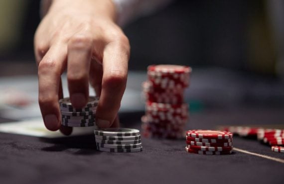a dealers hand shuffling up poker chips