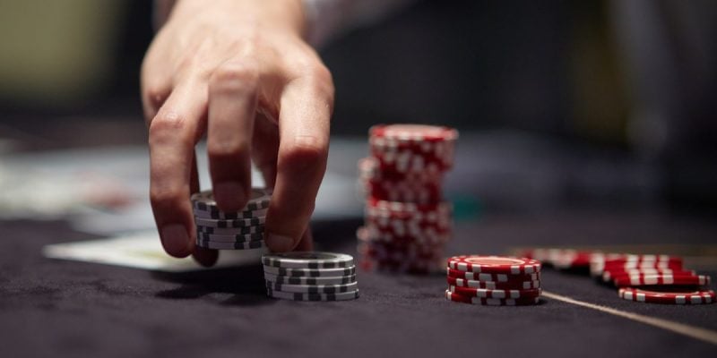 a dealers hand shuffling up poker chips
