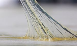 a sticky substance being stretched off a counter top