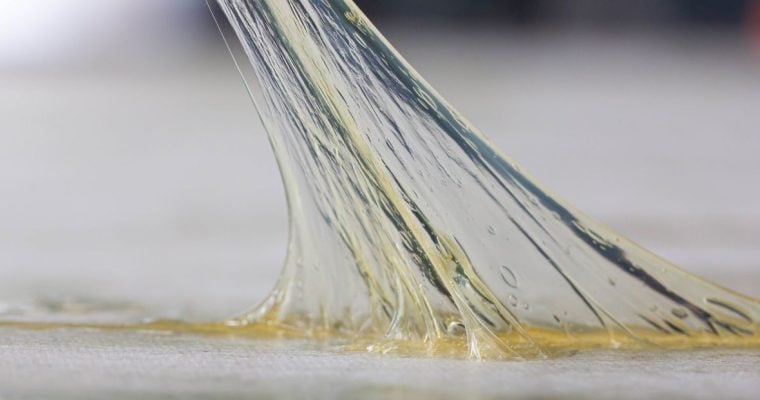 a sticky substance being stretched off a counter top