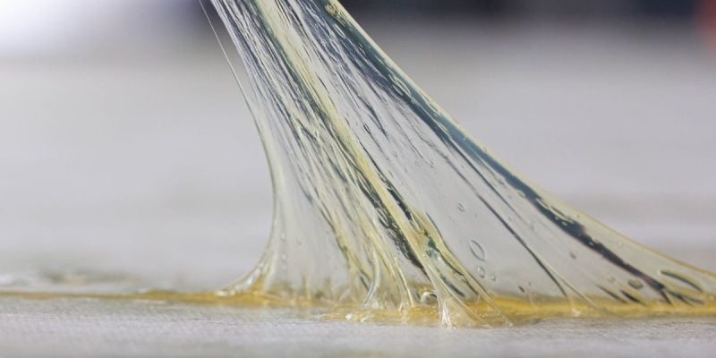 a sticky substance being stretched off a counter top