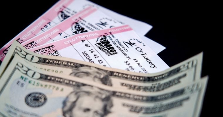 a trio of mega millions tickets next to two twenty dollar bills