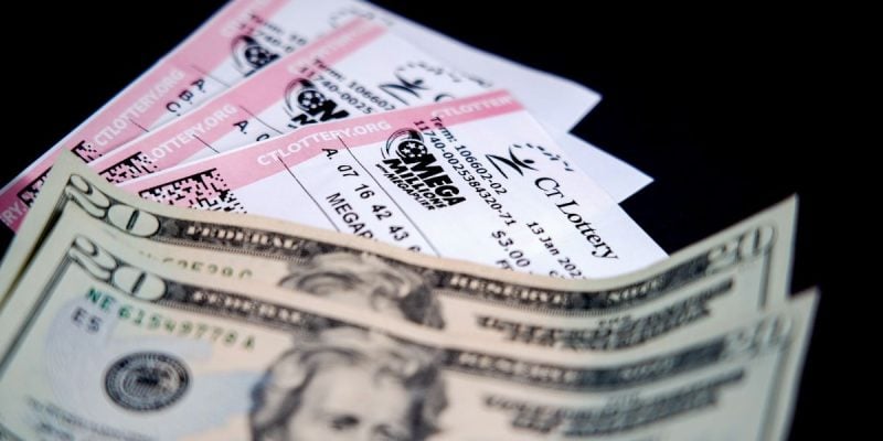 a trio of mega millions tickets next to two twenty dollar bills