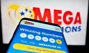 a mobile phone with mega millions winning number in front of a mega millions logo