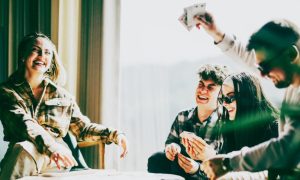 Friends Have Fun Playing Cards At a Table