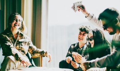 Friends Have Fun Playing Cards At a Table