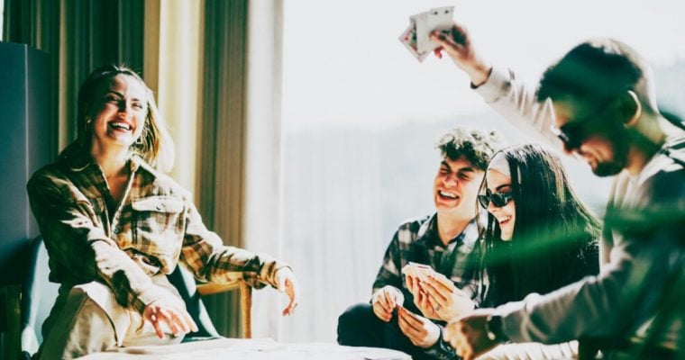 Friends Have Fun Playing Cards At a Table