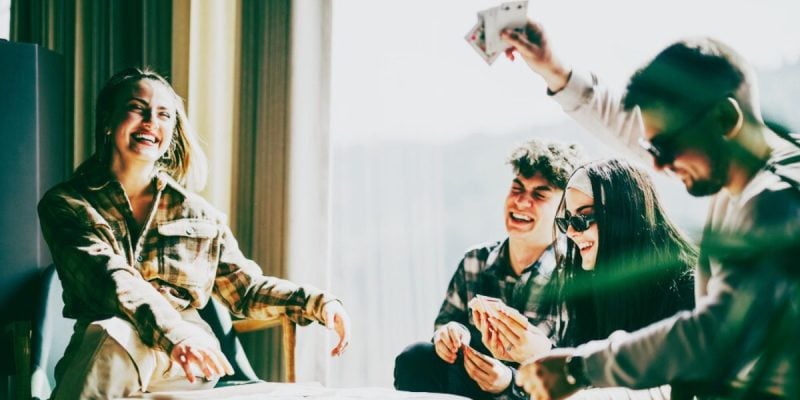 Friends Have Fun Playing Cards At a Table