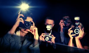 Three Paparazzi Point Flashing Cameras Inside a Car