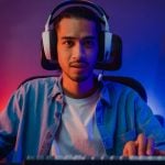 Young Black Man with Headphones Plays Game On Computer