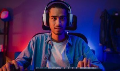 Young Black Man with Headphones Plays Game On Computer
