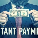 Man Holds Dollar In Cash with Phrase Instant Payment Below