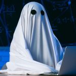 Person in Halloween Ghost Costume Sits At Laptop