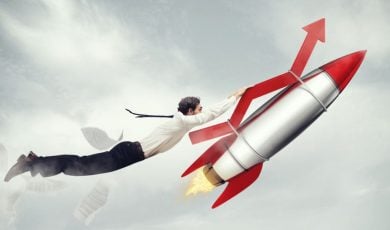 Red Financial Arrow Attached to Rocket Soars With Man Hanging On