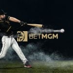 BetMGM Logo Sits Beneath Swinging Baseball Player Hitting Baseball on Field