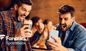 Two Men Celebrate Winning Sport Bet On Cell Phone with Fanatics Sportsbook Logo