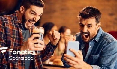 Two Men Celebrate Winning Sport Bet On Cell Phone with Fanatics Sportsbook Logo