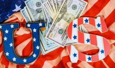 American Cash Lays On Top of the American Flag with U.S. Letters