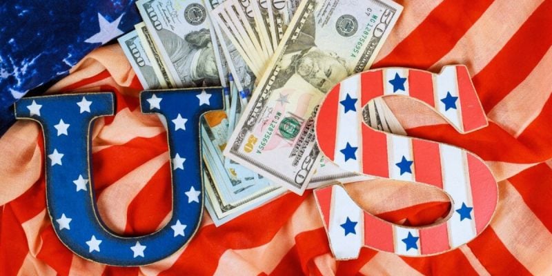 American Cash Lays On Top of the American Flag with U.S. Letters