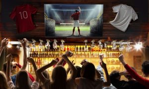 People In Sports Bar Cheer While Watching Football on TV