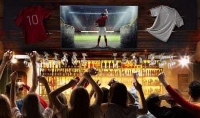 People In Sports Bar Cheer While Watching Football on TV