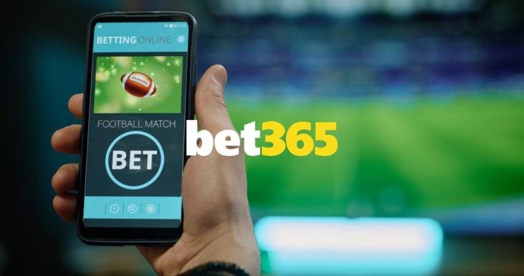 Bet365 logo Centered Over Man Holding Cell Phone and Watching Game on TV