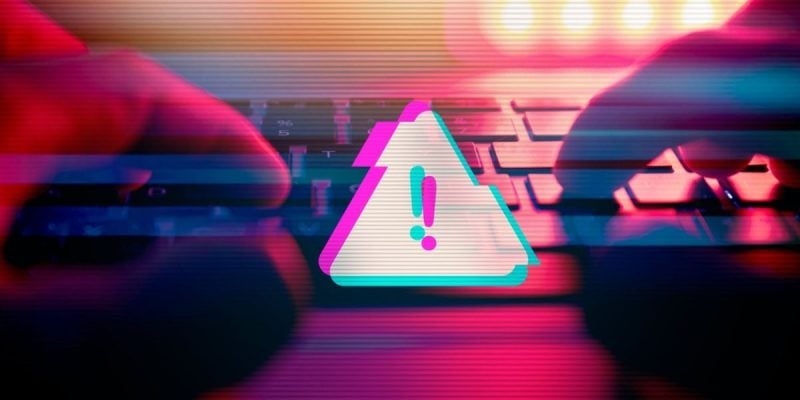 Triangle with Exclamation Mark Represents Digital Scam Warning with Hands Touching Keyboard