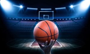Brightly-Lit Basketball Court with Empty Seats and Man Holding Basketball