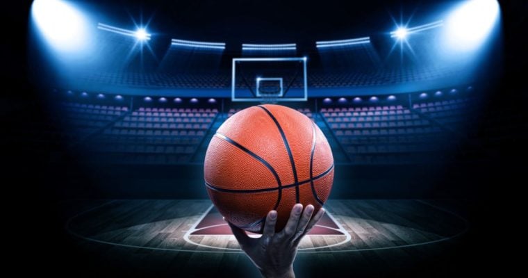Brightly-Lit Basketball Court with Empty Seats and Man Holding Basketball