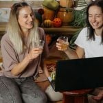 Friends Toast While Enjoying Game in Front of Laptop at Home
