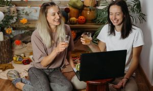 Friends Toast While Enjoying Game in Front of Laptop at Home