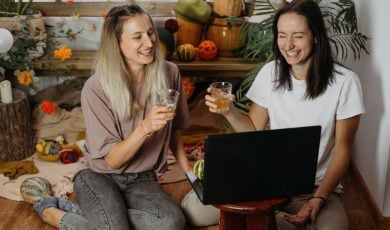 Friends Toast While Enjoying Game in Front of Laptop at Home