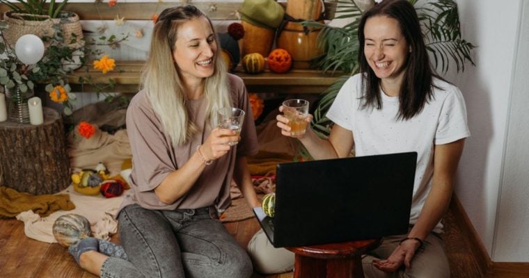 Friends Toast While Enjoying Game in Front of Laptop at Home