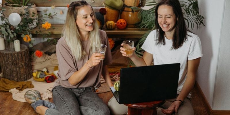 Friends Toast While Enjoying Game in Front of Laptop at Home
