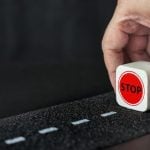 Man Holds Small Wood Block Reading 