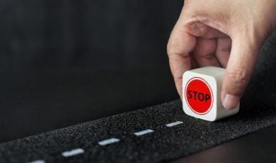 Man Holds Small Wood Block Reading 